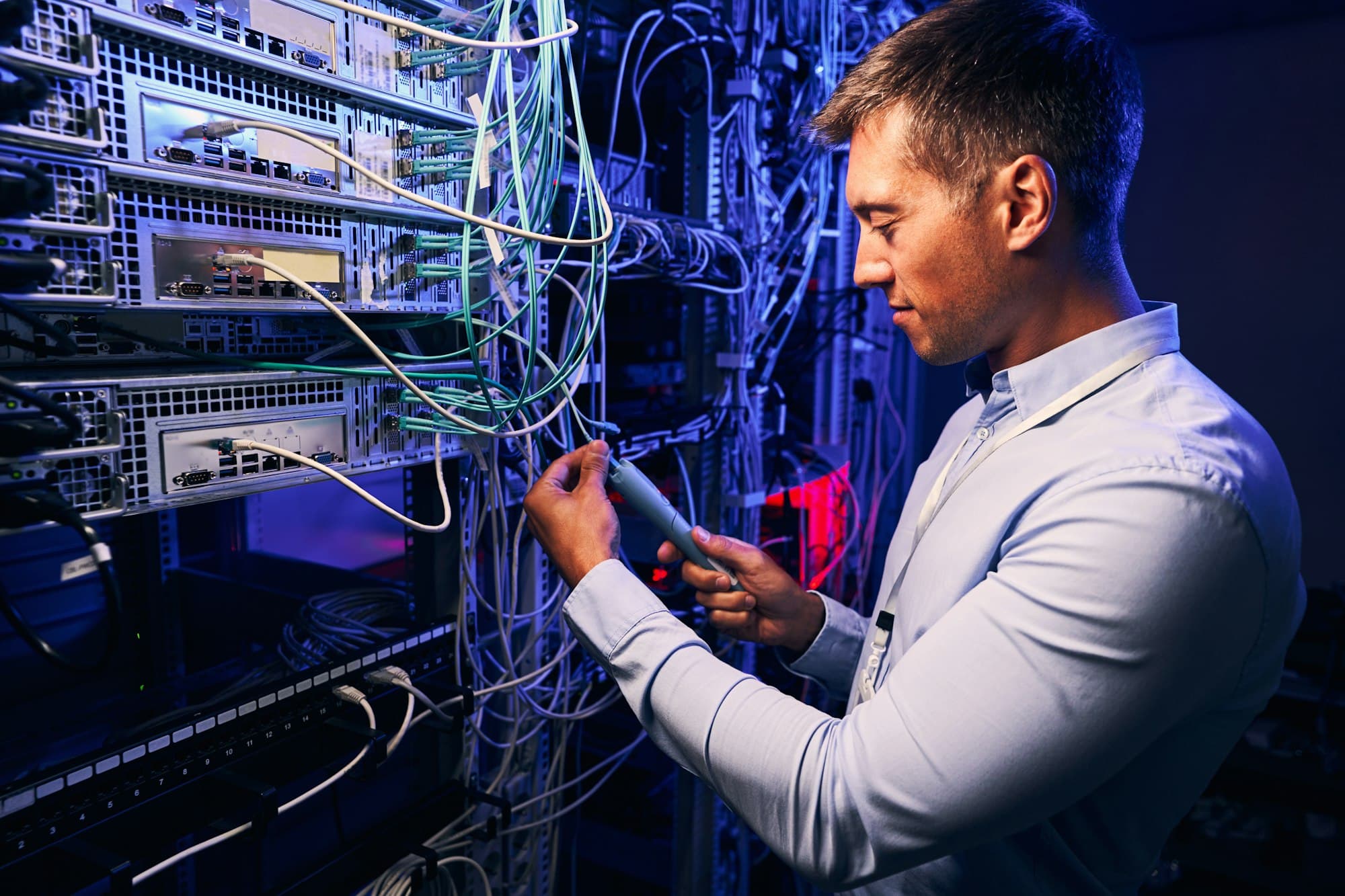 A technician checking cabling in a data centre