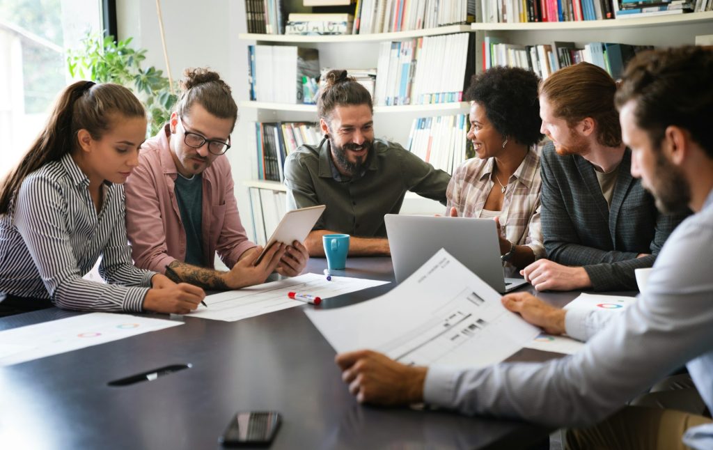 Diverse employees gathered in the office having fun during brainstorming while discussing new ideas